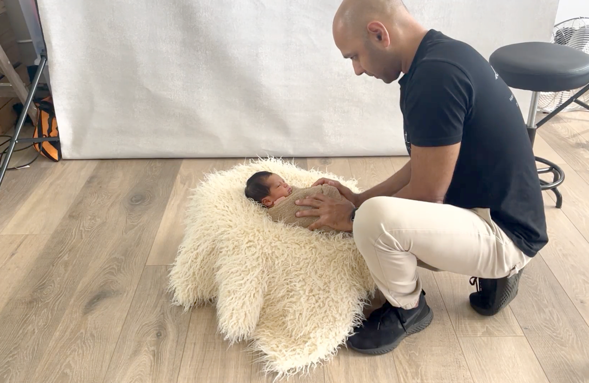 Handling newborn baby at family photo shoot